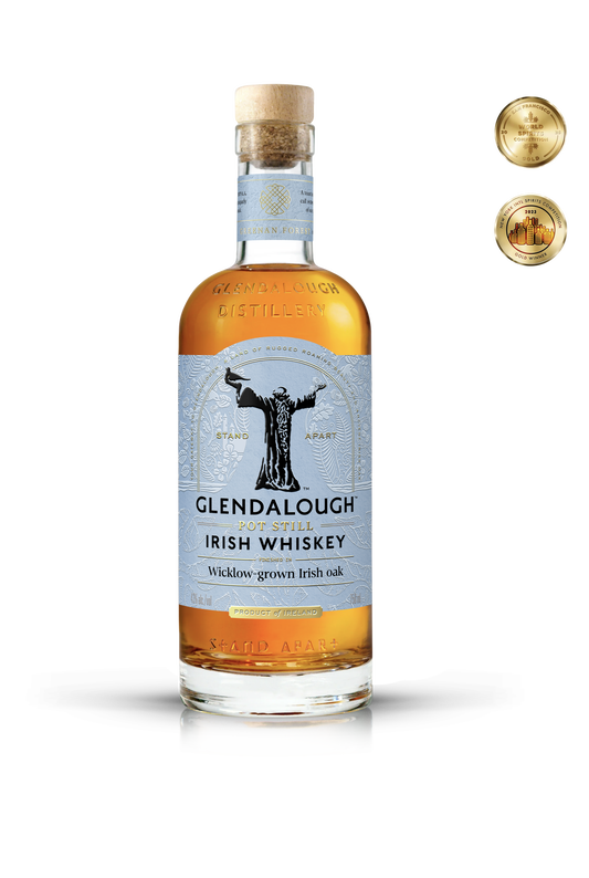 A bottle of Glendalough Pot Still Irish Whiskey with a cork stopper, featuring a gold emblem on a white textured label and two gold award medals in the top right.